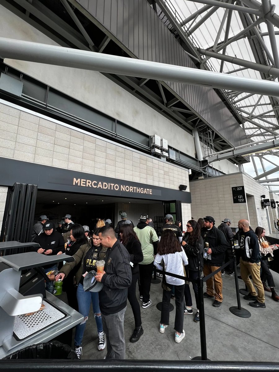 A crowd moves through a concessions stand with Mashgin kiosks